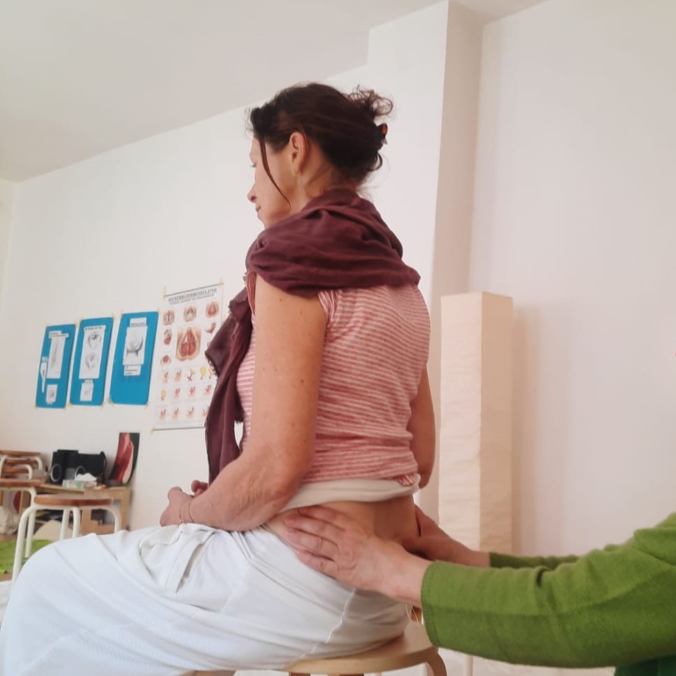 Frau behandelt Frau am hinteren unteren Rücken